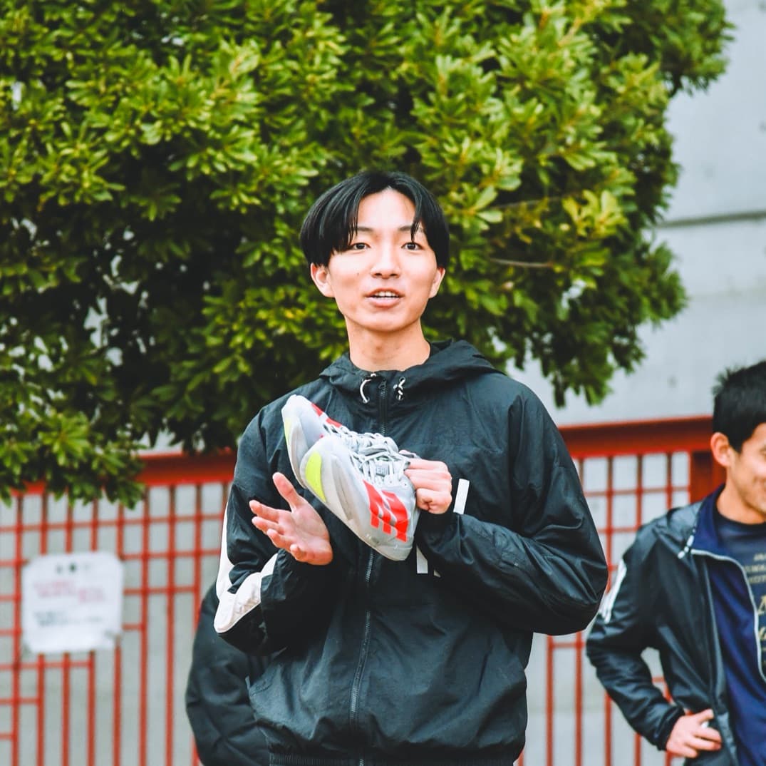 ランニングシューズを持って話す布野雅也